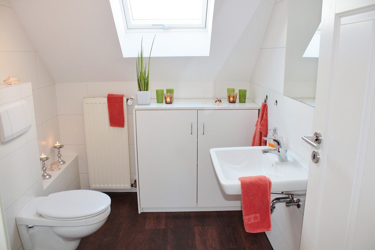 white tile bathroom with brown wood flooring